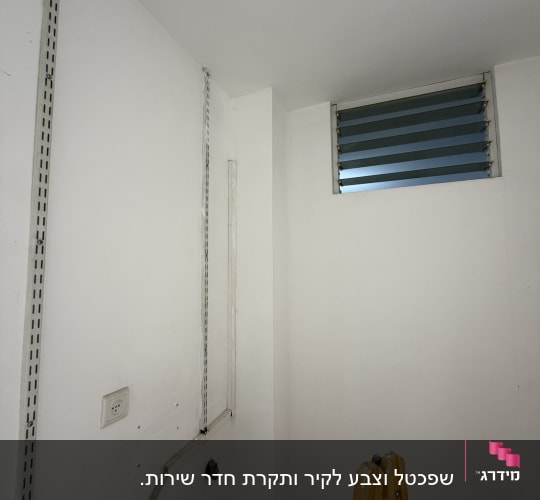 קיר לבן עם חלון קטן וסולם צהוב